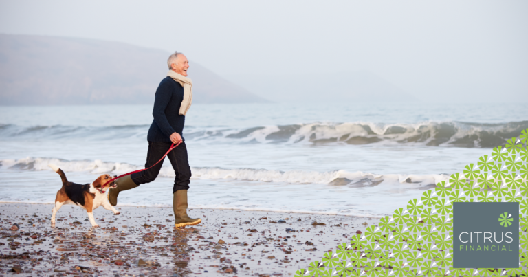 Senior adult walking his dog on a beach