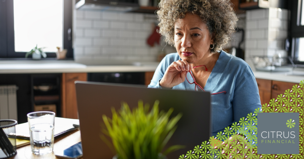 Middle aged woman looking at laptop with a concerned look