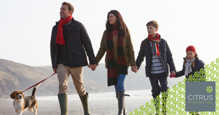 A father, mother, and two children walking on a beach in the winter