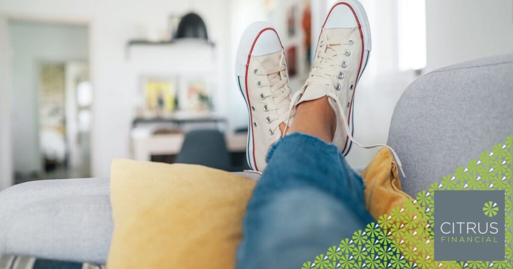 A woman with her feet on the sofa representing the cost of delaying financial planning.