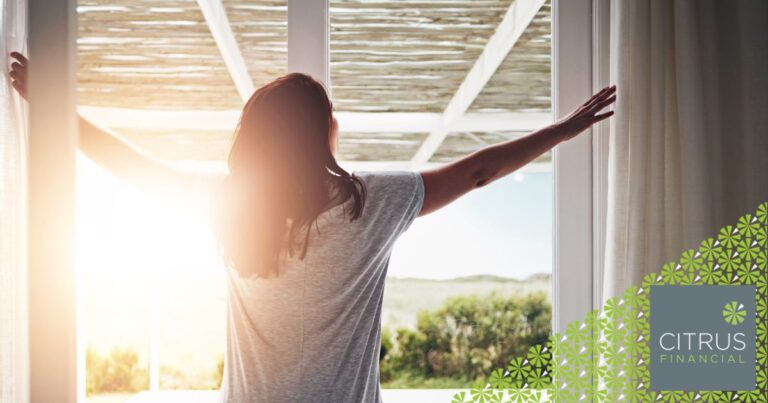 Woman looking out at rising sun, representing a new start