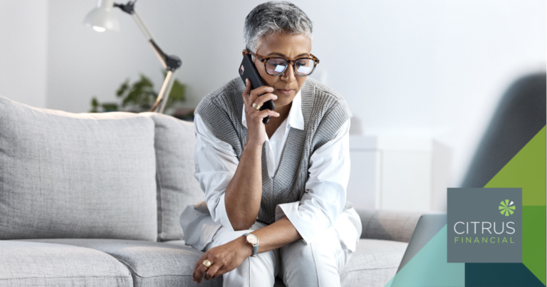 Woman looking concerned while receiving a phone call and using a laptop